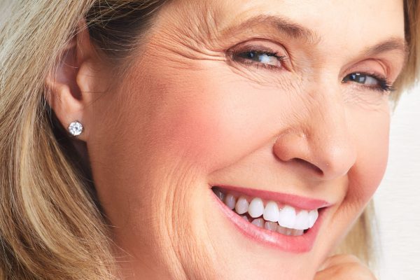 Senior smiling woman portrait. Over grey background.